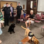 Officer Cooper and Rusty in the Select Board meeting room.