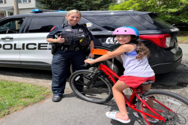 Reading Police Officer Kaylyn Balbo presents a citation to a girl who was seen riding her bike with a helmet on. (Courtesy Reading Police Department)