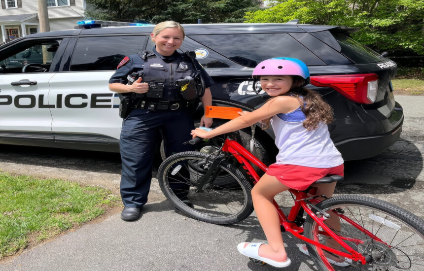 Reading Police Officer Kaylyn Balbo presents a citation to a girl who was seen riding her bike with a helmet on. (Courtesy Reading Police Department)